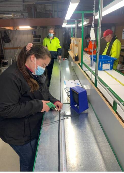 STRONGER TOGETHER: Pinnacle worker Rachel is cutting the new braid tube with the heat knife under AME staff member Christian's careful watch. Picture: FACEBOOK