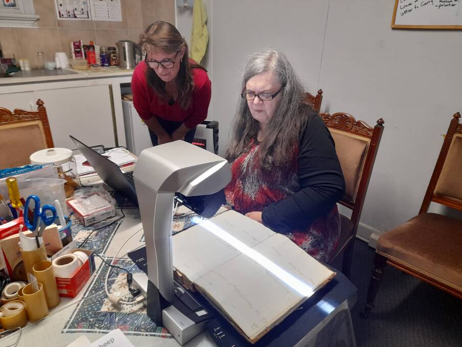 HISTORY: Langi Morgala Museums Sandra Audsley watches Debbie Squires scan an old bank ledger. Picture: Contributed. 