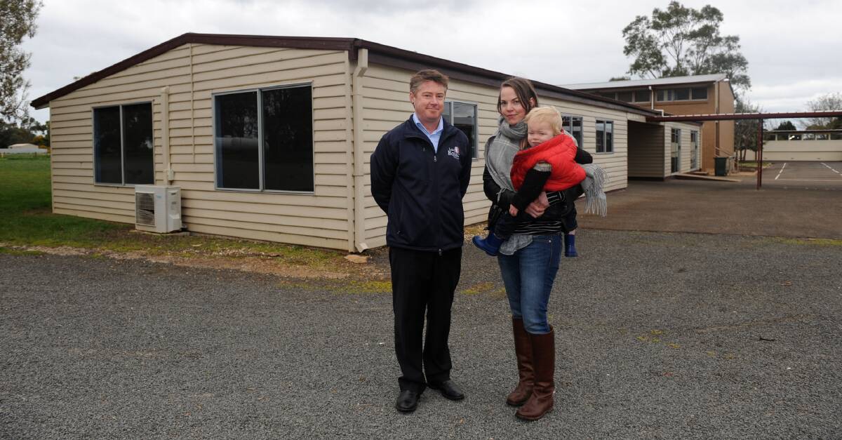 REFURBISHMENT: Lake Bolac P-12 College principal George Porter with Karen Davidson and Erik, 1, at the site of the proposed family day care facility. Picture: SAMANTHA CAMARRI. 