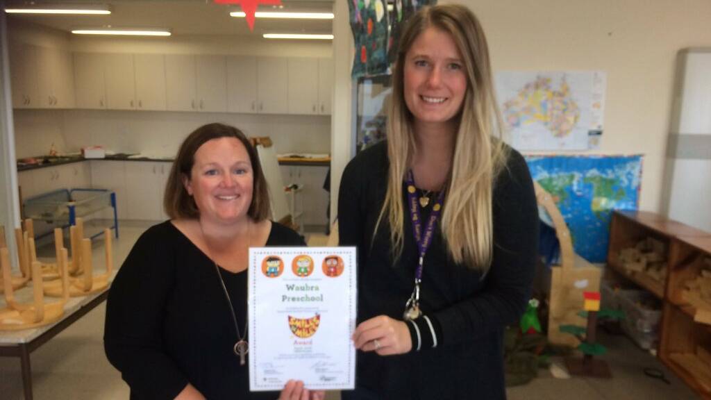 GRINNING: Kinder assistant Gemma Murphy and teacher Laura Dunnett with their Smiles 4 Miles award. Picture: CONTRIBUTED