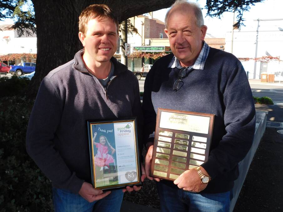 Graeme Cooper, Ararat Area Manager for the Royal Children's Good Friday Hospital Appeal, with Aradale Golf Club president Ken Mahney, Mr Mahney is holding the club's shield. Picture: MICHELLE DE'LISLE 