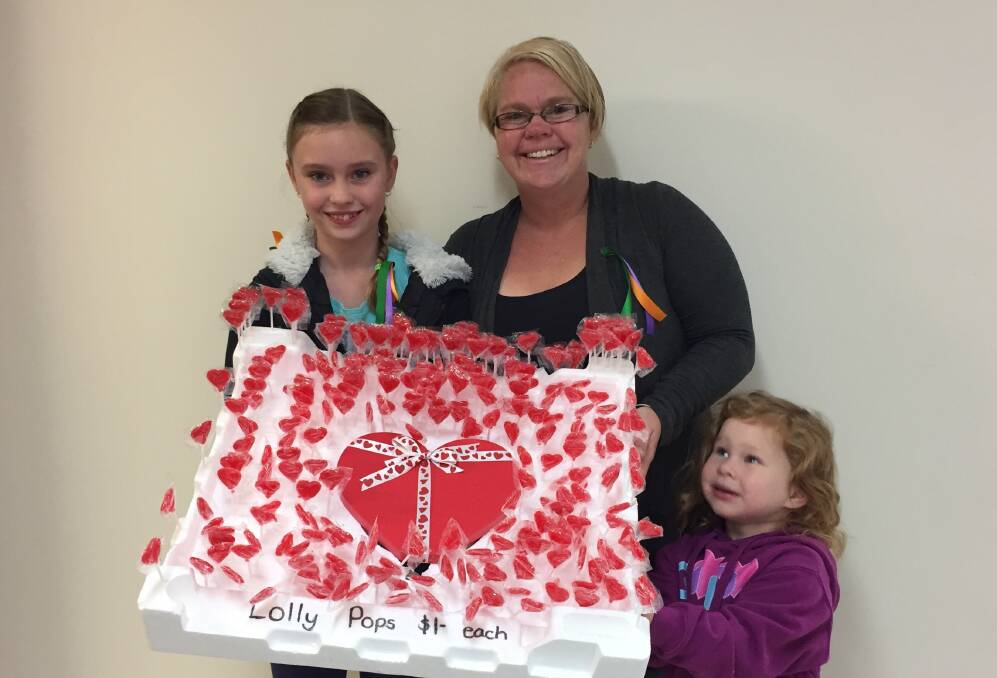 SPECIAL DELIVERY: Rahni Cooper with mum Rosie and little sister Lexi bring heart-shaped lollypops to school for a personal touch to her fundraising campaign to help the Good Friday Appeal.