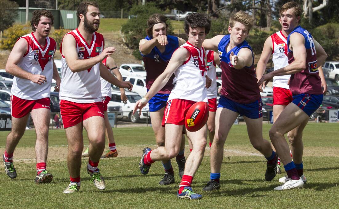 RUSHED: Ararat's Liam Arnott gets a kick away despite the pressure from Horsham opponents during the reserves semi-final on Sunday. Picture: Peter Pickering