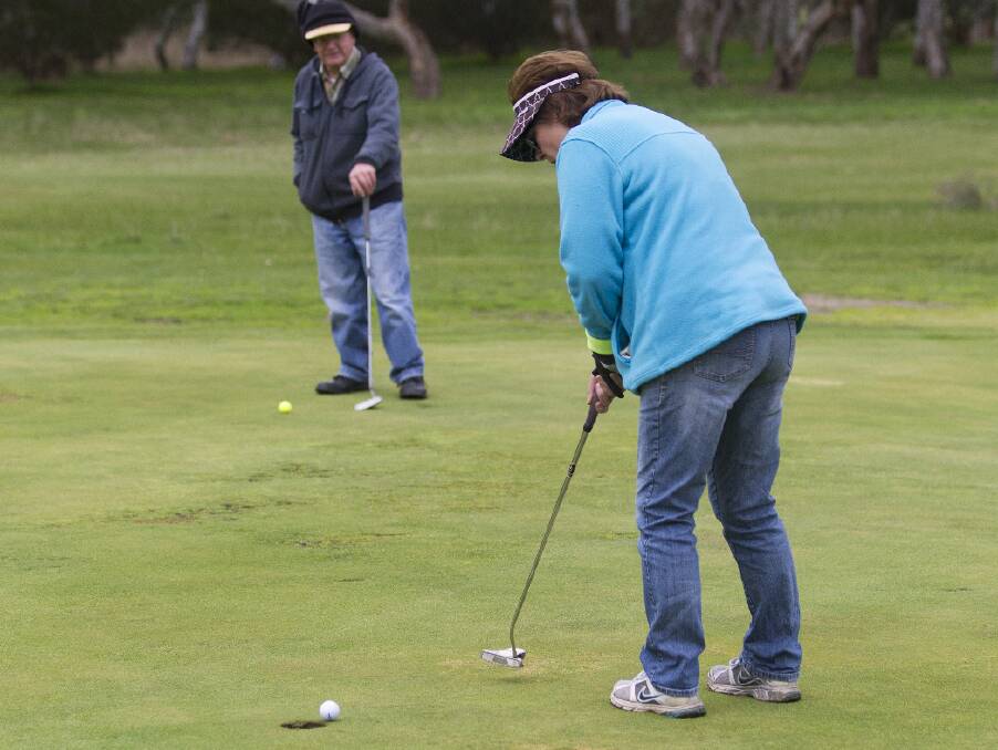 IN THE CUP: Gaye Collins sinks her putt from point blank range. Saturday's round was a good one for Collins who claimed nearest the pin on the ninth hole.