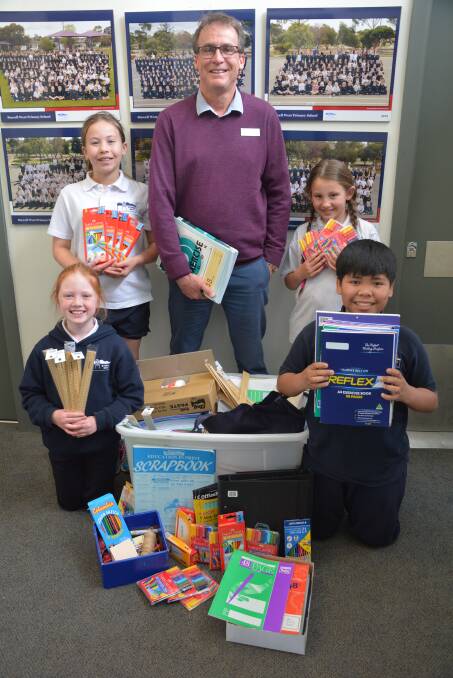 GENEROUS: Stawell West Primary principal Jim O'Brien stands with pupils holding stationary soon to be donated. 