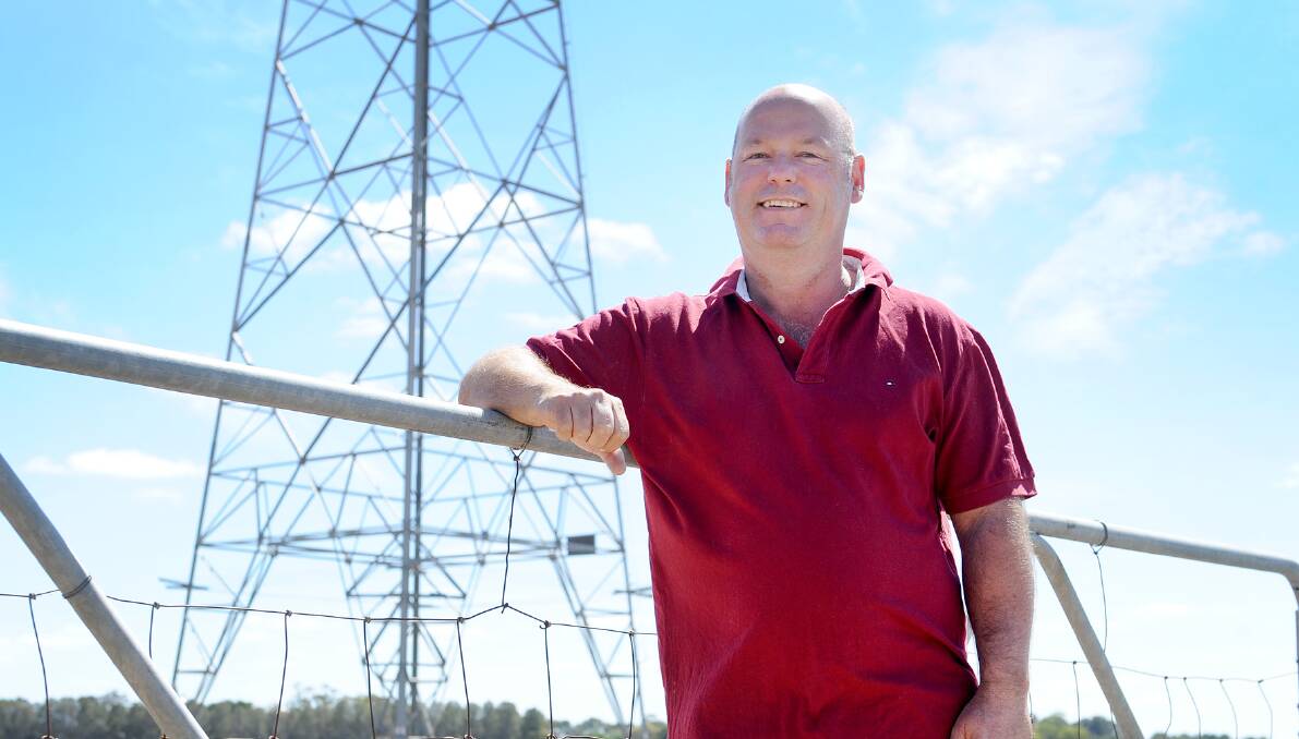 Wallup grain farmer Simon Tickner next to the high-voltage line that the Murra Warra wind farm project hopes to make use of. Picture : AYESHA SEDGMAN