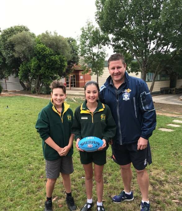 DONATION:  AFL Victoria football development manager Jason Muldoon presents new footballs to Ararat West Primary School. Picture: CONTRIBUTED