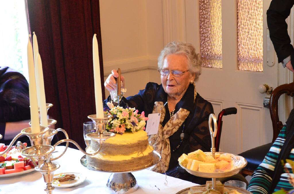 Mary Pope is pictured cutting the cake celebrating her 100th birthday.