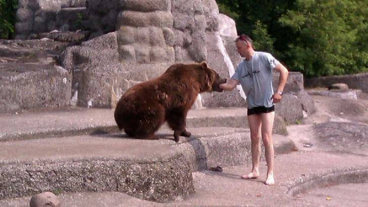 The bear appears to have the man by the arm. Photo: Imgur