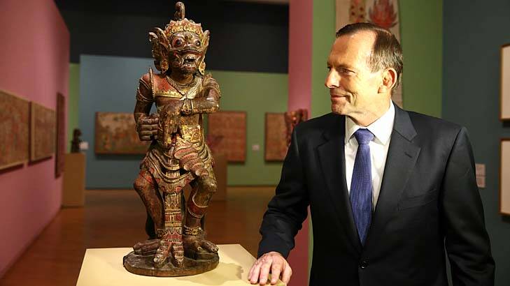 Soft diplomacy: Tony Abbott casts his eye over one of the treasures in Bali: Island of the Gods, after he opened the exhibition at the National Gallery. Photo: Alex Ellinghausen