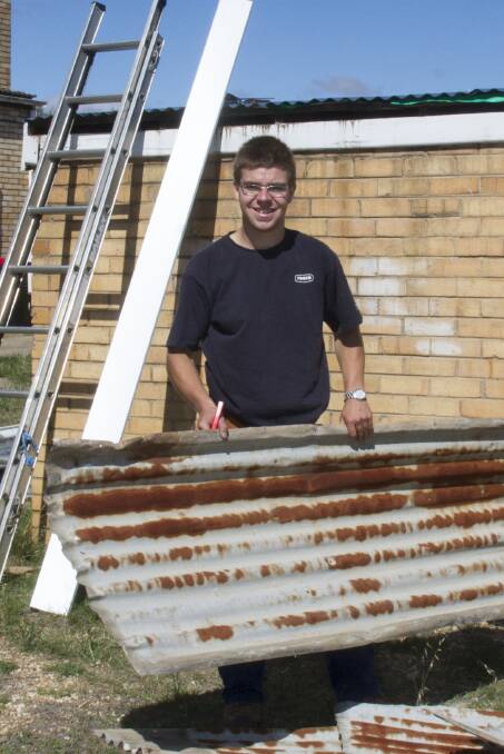 Matthew Harrington from Hogans plumbing re roofs the old toilet block at the Scout hall, which is being funded through a grant from Pacific Hydro. 