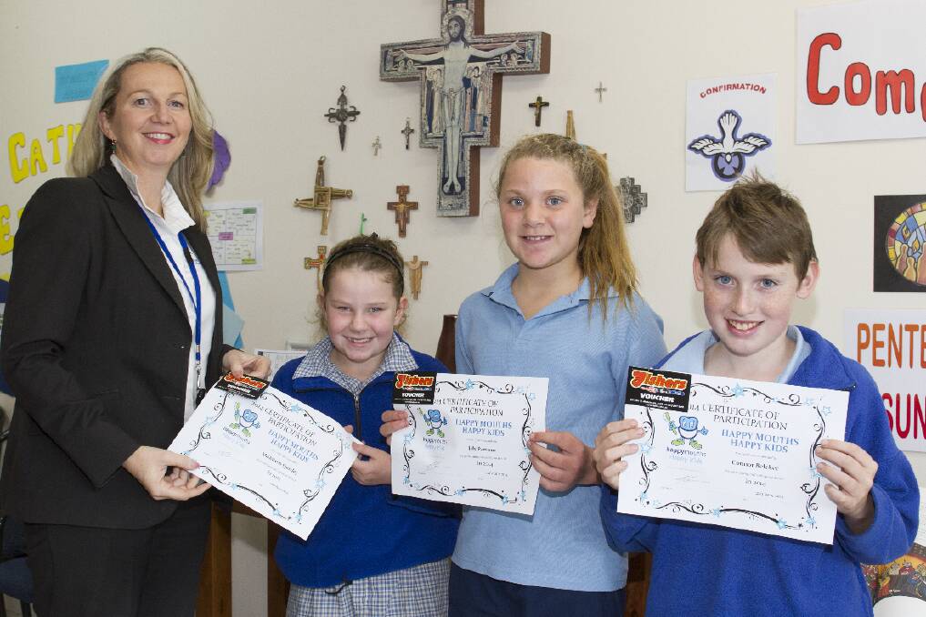Anna Greene presents dental certificates to St Mary s Primary School students Maddison, Lily and Connor.