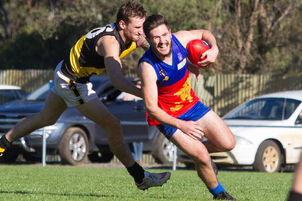Great Western s Mitchell Hoare evades Woorndoo/Mortlake opponent Matthew Kleeven during the Lions second victory of the season on Saturday. Picture: PETER PICKERING