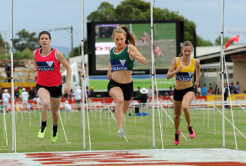 Sarah Blizzard (centre) crosses the fi nishing line in second position during the final of the State of Victoria Strickland Family 120m Women’s Gift. Picture: PAUL CARRACHER