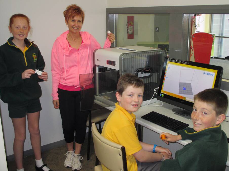 Former student Lily Hitchcock, Parents and Friends member Fiona McLoughlin, school captain Jack Ward and former school captain Charlie Preston with the new 3D printer at Ararat West Primary School.