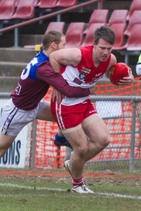 Ararat midfielder Daniel Mendes is wrapped up in a tackle by his Horsham Demons’ opponent during Saturday’s match at Alexandra Oval.