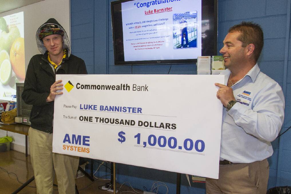 Weight loss challenge winner Luke Bannister (left) accepts a cheque from Dean Pinniger at AME Systems. Picture: PETER PICKERING
