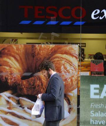 A customer passes a branch of the Tesco Express convenience store in central London.  Photo: Toby Melville
