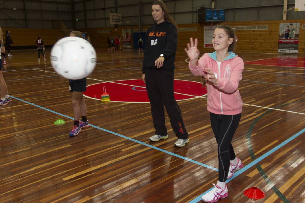 Kate fires off a pass under the guidance of North East Blaze netballer Mikayla Wilson. Pictures: PETER PICKERING