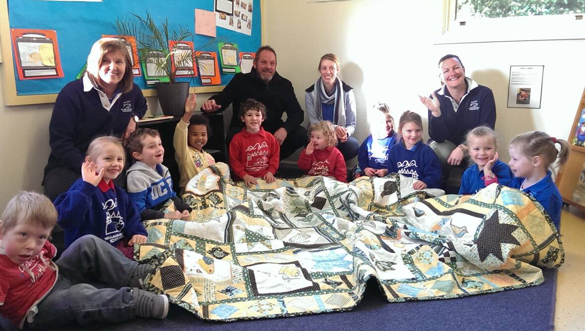 Jacob Warrior-Day (far left) with members of the Willaura and District Kindergarten and the quilt made by the Willaura and District Quilters Group which was raffled to help raise money for a wheelchair for Jacob.