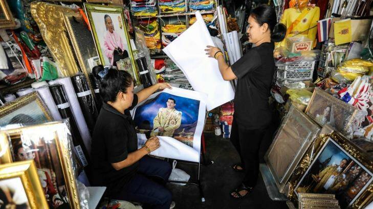 Vendors prepare portraits of Thai Crown Prince Vajiralongkorn for sale at a shop. Photo: Dario Pignatelli