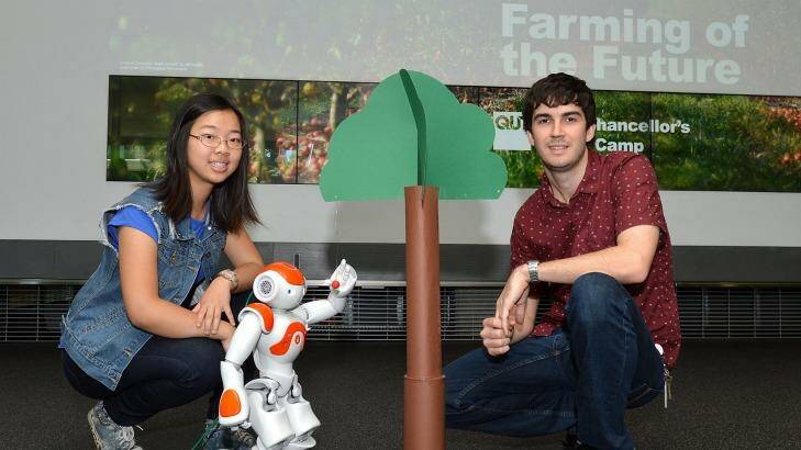 Student Eva Wang and QUT lecturer Christopher Lehnert with a robot designed to pick fruit. Photo: Bradley Kanaris