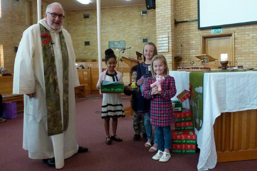 Reverend Colin Honey with Sarona and Harley, Madelene and Delinda collecting gifts to send overseas.