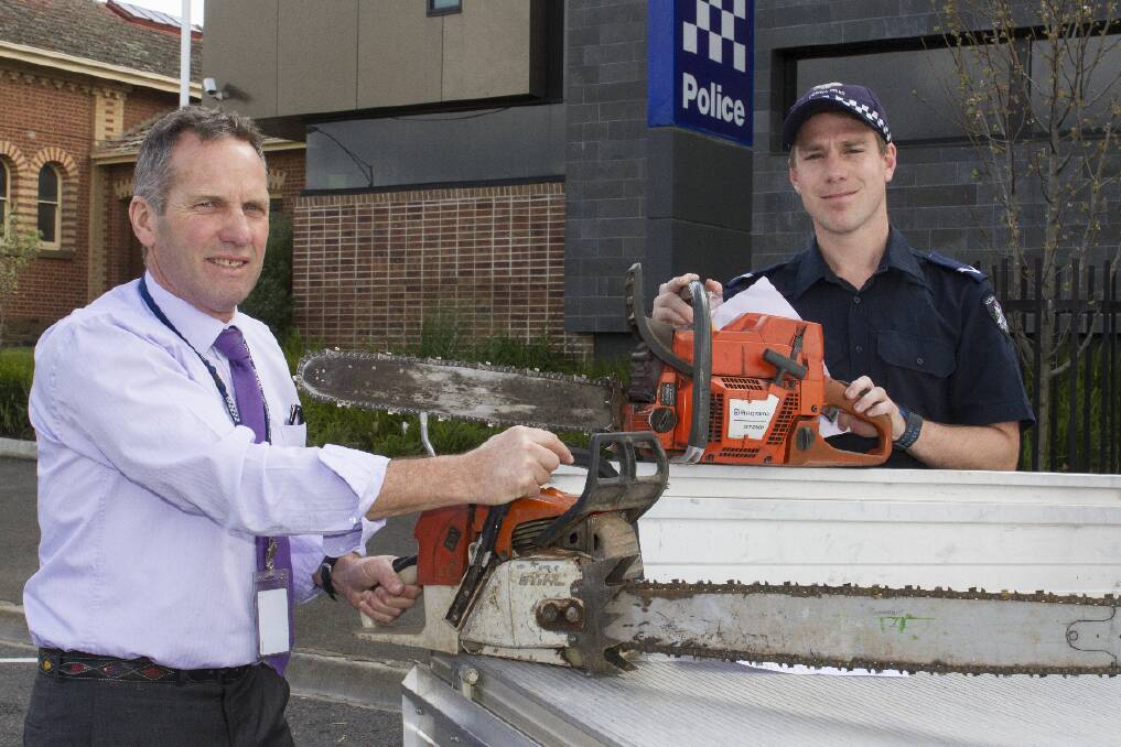 Detective Senior Constable Steve Oliver and First Constable Daniel Mendes with recovered stolen chainsaws.