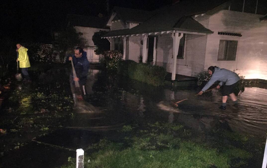 Neighbours help divert water from a house in Breen Street, Murtoa. Pictures: CONTRIBUTED