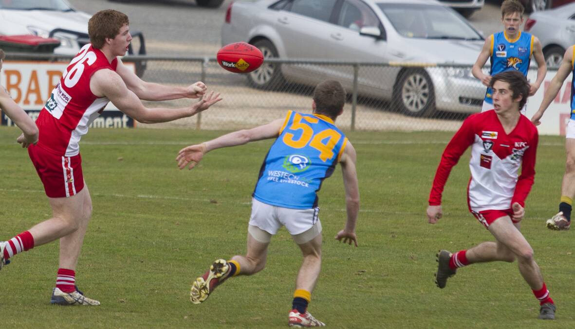 Matt North gets a handpass away to his Rats' team mate Tyler Cronin during last weekend's clash with Nhill at Alexandra Oval. Ararat must travel to Central Park and beat Stawell to have any hope of playing finals this season. Picture: PETER PICKERING.