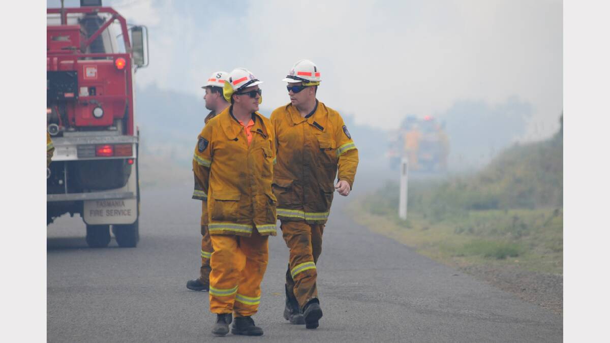 Firefighters discuss tactics at the fire at Lefroy yesterday. Picture: Geoff Robson