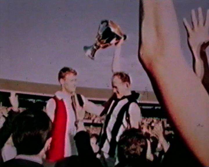 St Kilda captain Darrell Baldock in Collingwood jumper holds up the premiership cup. Fairfax photos.