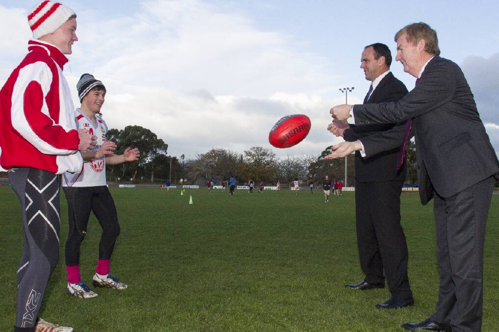 Ararat Rats' under 17 captains Riley Taylor and Aidan Moar practice their handball with Scott Turner and Deputy Premier Peter Ryan last week. Picture: PETER PICKERING