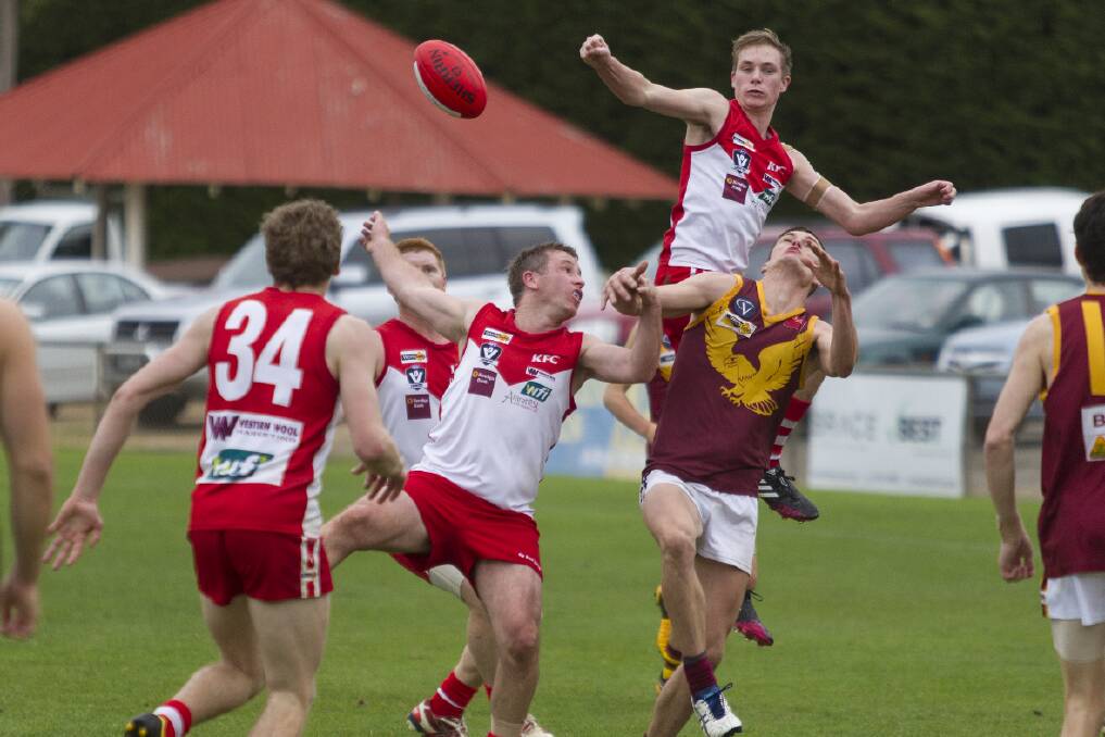 Ararat defender James Hosking flies over the top of his Warrack Eagles’ opponent and team mate Aaron Searle to make the spoil during Saturday’s match at Alexandra Oval. The Rats lost the battle for second spot on the Wimmera ladder by one point.