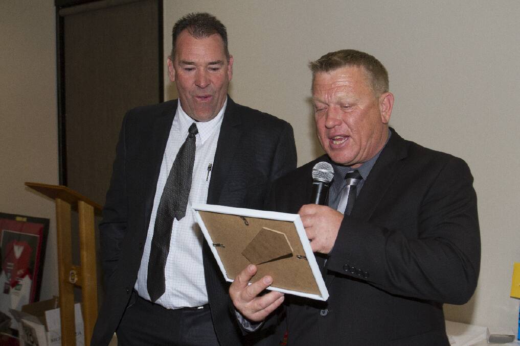 Rod Mills receives the Rats’ best clubman award from Ararat Football-Netball 
Club president Bill Bell.