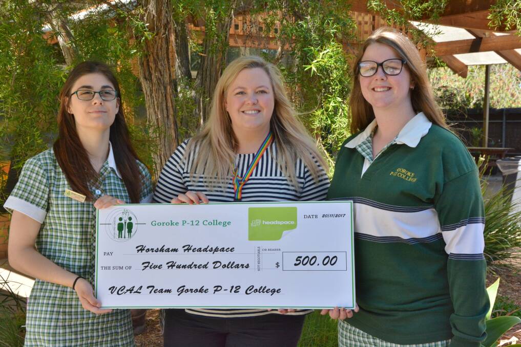 Goroke P-12 College VCAL students, Lucy Cardwell and Daphne Williams, present headspace Horsham's Emma Hynes with funds raised at a recent trivial night.