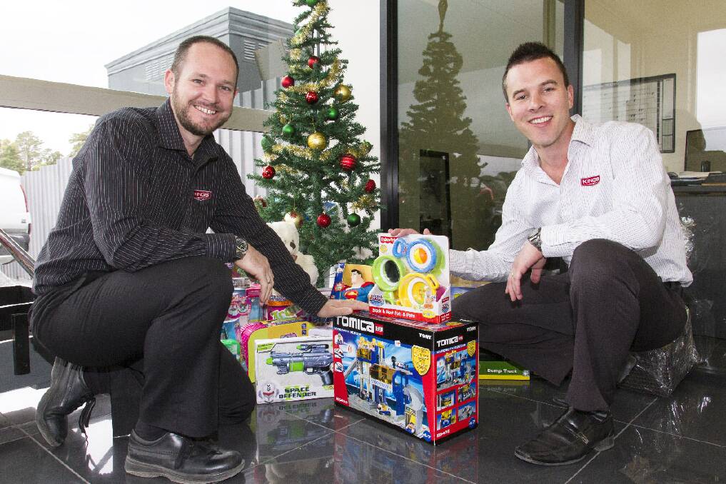 John Grayling and Michael Smith are urging people to place gifts below the Christmas tree at Kings Cars for Ararat Emergency Relief. Picture: PETER PICKERING
