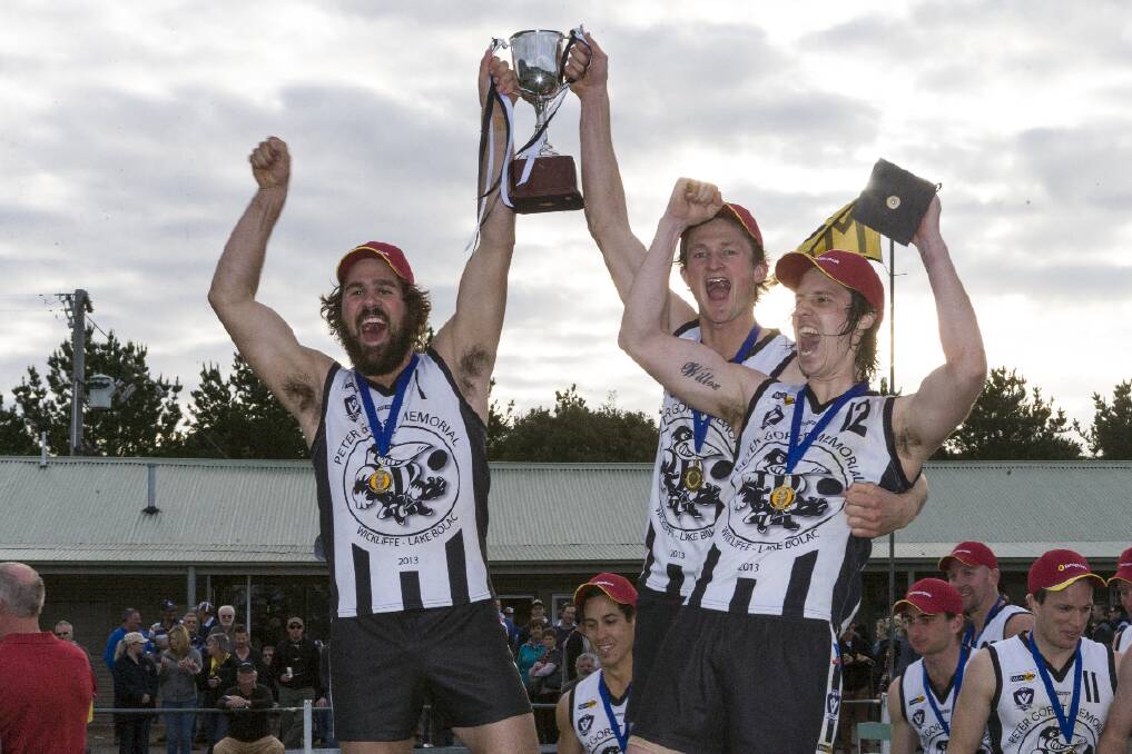 Lake Bolac-Wickliffe coach Nic Willox on right and captains Charlie Archer and Tom Gibson hold the Premiership Cup aloft
