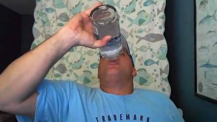 A man removes the plastic seal on a one-litre bottle of vodka and drinks its entire contents in less than 15 seconds in a game of Neknominate.  Photo: Facebook