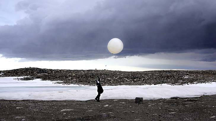 Up, up and away: Steven Black launches a weather balloon at Casey station in Antarctica. Photo: Colin Cosier