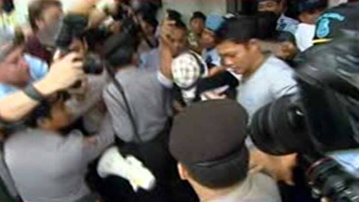 Media scrum: Schapelle Corby, wearing a checked hat, leaves Kerobokan prison.