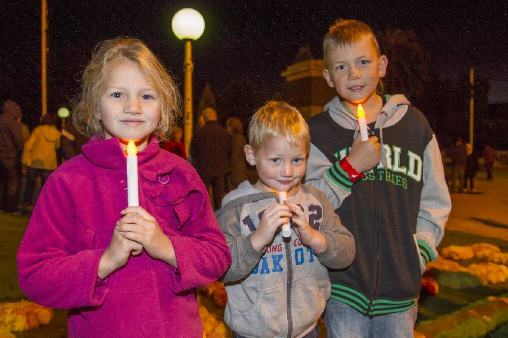 Up early to remember the fallen. Chelsea, Hudson and Cameron Bahl are pictured with their candles at this year's Anzac Day Dawn Service. 
