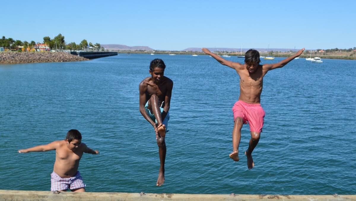Isaac Haines,  Brodrick Newchurch and Sean Reid try some jetty jumping to cool off during the heatwave in Port Augusta, South Australia.