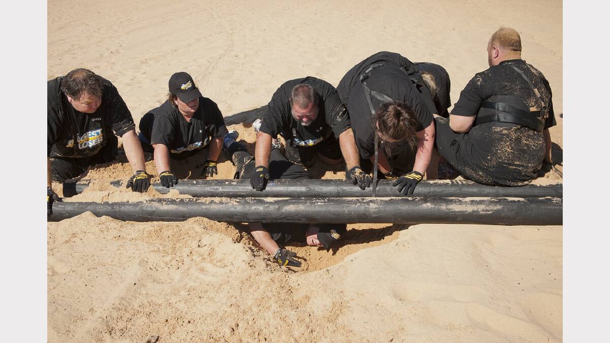 The Black team, L-R, Craig, Sharon, Kerry, Caitlin and Cal help Jane make her way under a log in the Chains of Pain challenge. Pictures: NETWORK TEN