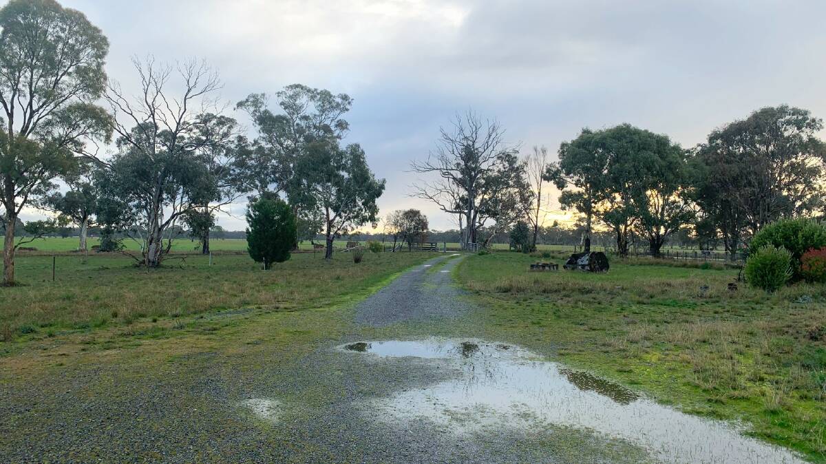 RAINY: A rain soaked property as the sun peeks through the clouds. Picture: ALISON FOLETTA
