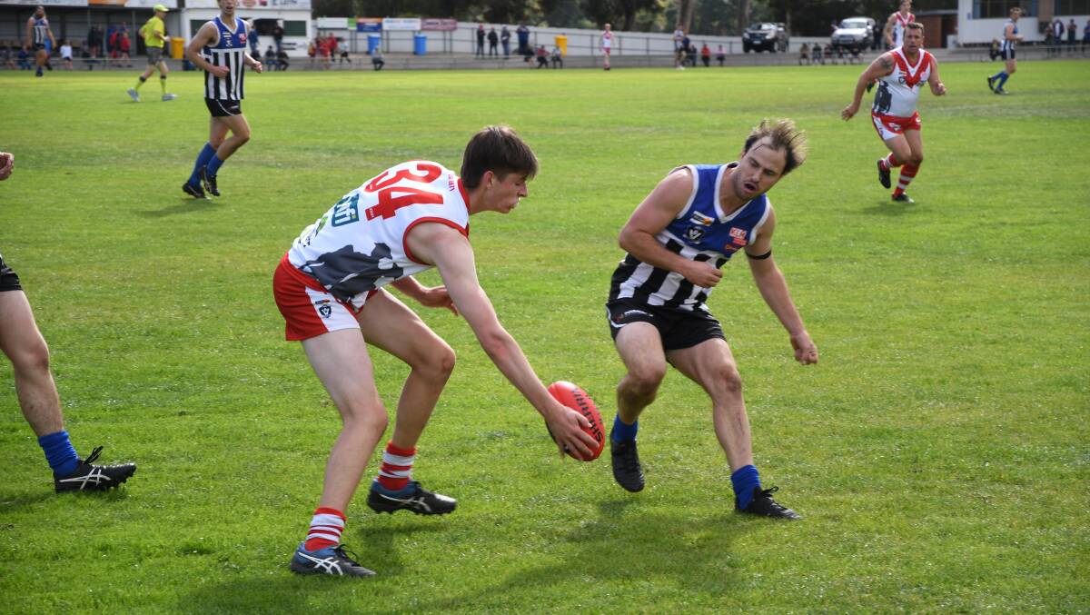 QUICK HANDS: Ararat Reserve's Liam Arnott bravely sweeps in for the ball despite the oncoming challenge. Picture: MATT HUGHES