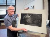 PROUD: Ian Kemp, photographer, preparing print work for his exhibition. Picture: CONTRIBUTED.
