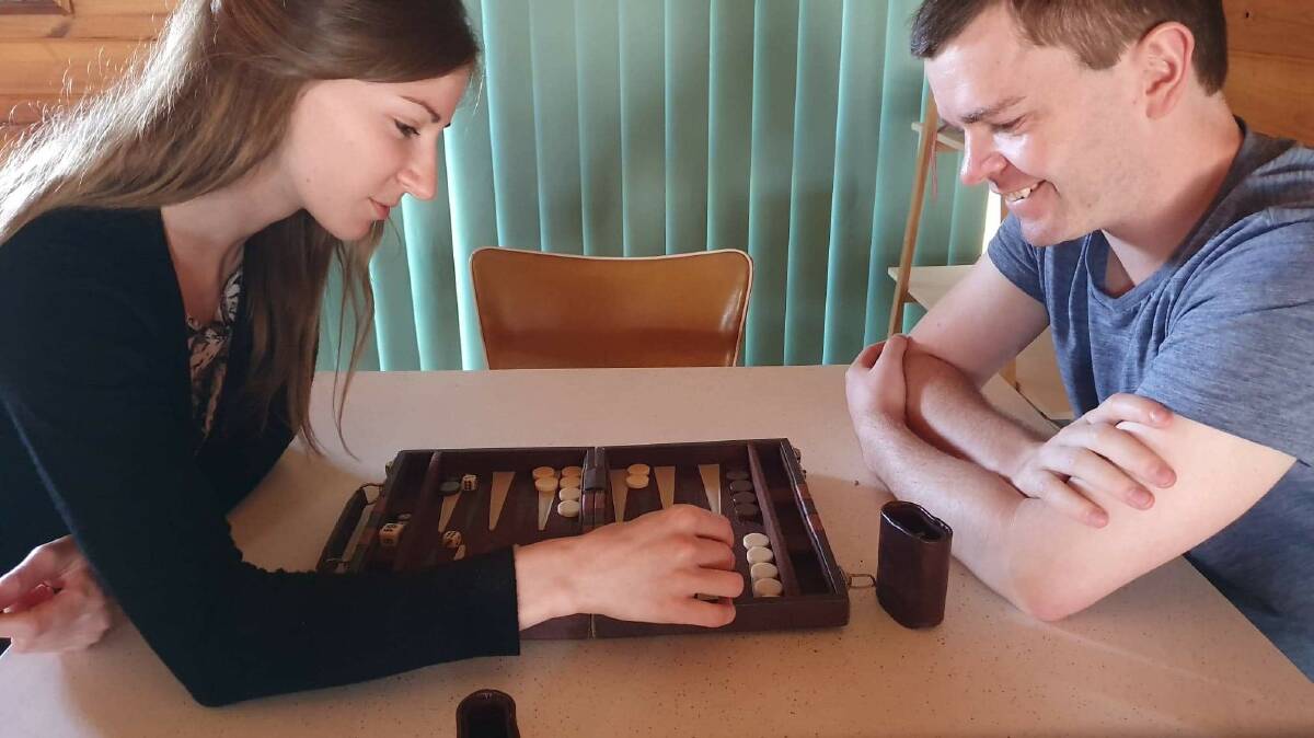 NEW PASTIME: Nicholas Pridan studies the backgammon board with best friend Telisia. Picture: SUPPLIED