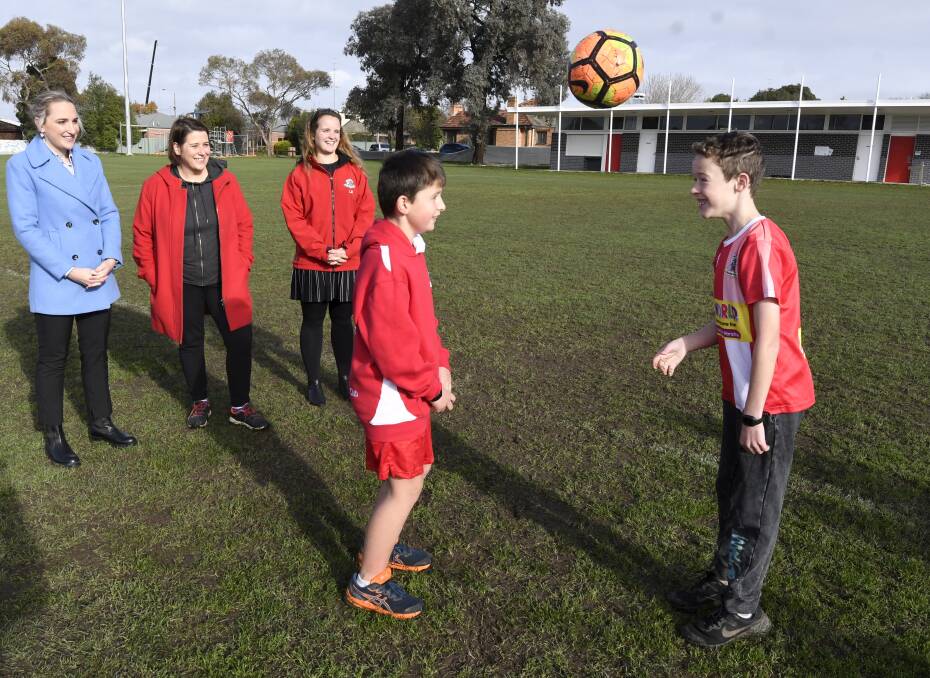 GROUNDED: City of Ballarat deputy mayor Amy Johnson, Wendouree MP Juliana Addison and Ballarat Soccer Club president Lucy Brennan watch 10-year-old Brock Smith and 10-year-old Baxter Withington have fun on the heavy, muddy Pleasant Street pitch. Picture: Lachlan Bence