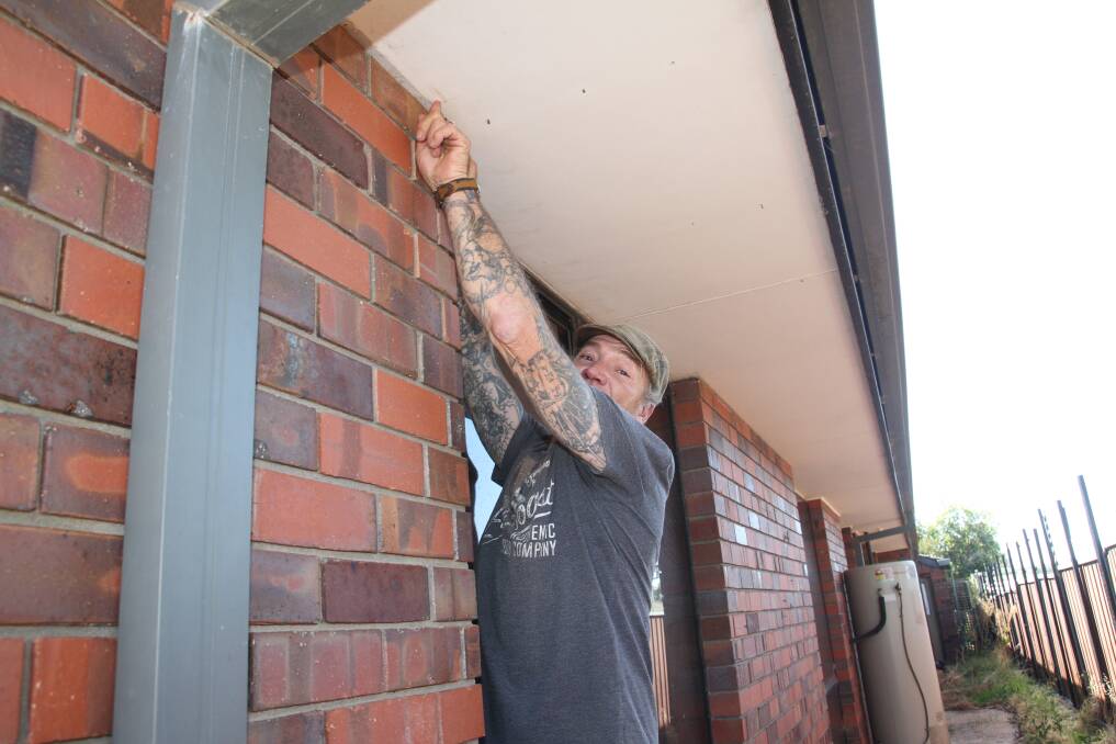 MOVEMENT: Stephen Leek, who bought a house knowing it had structural issues, points to how far the brick wall has moved at his Luke Street property in Stawell. Picture: PETER PICKERING